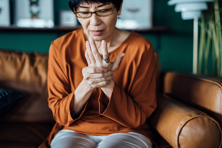 Asian elderly woman in glasses,thinking with hand on chin in her