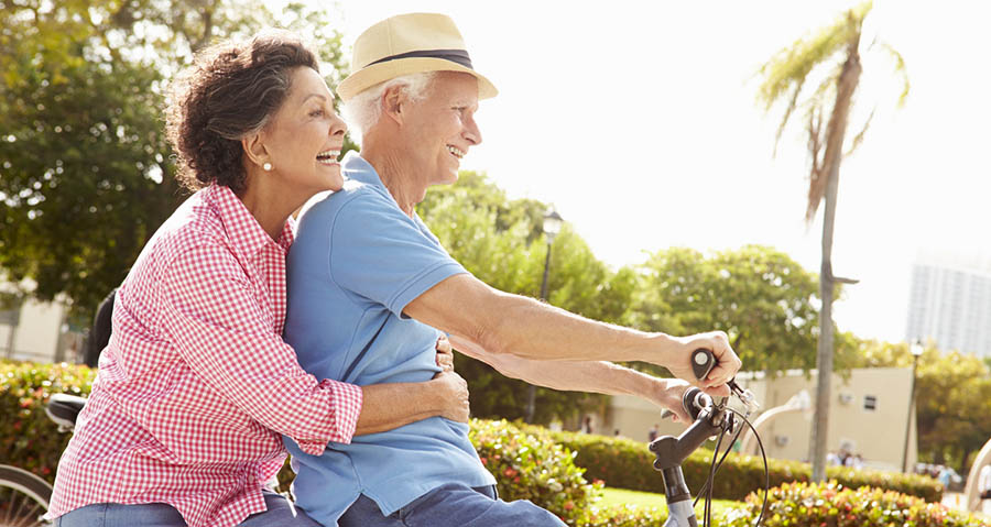 Older couple riding a bike to stay healthy