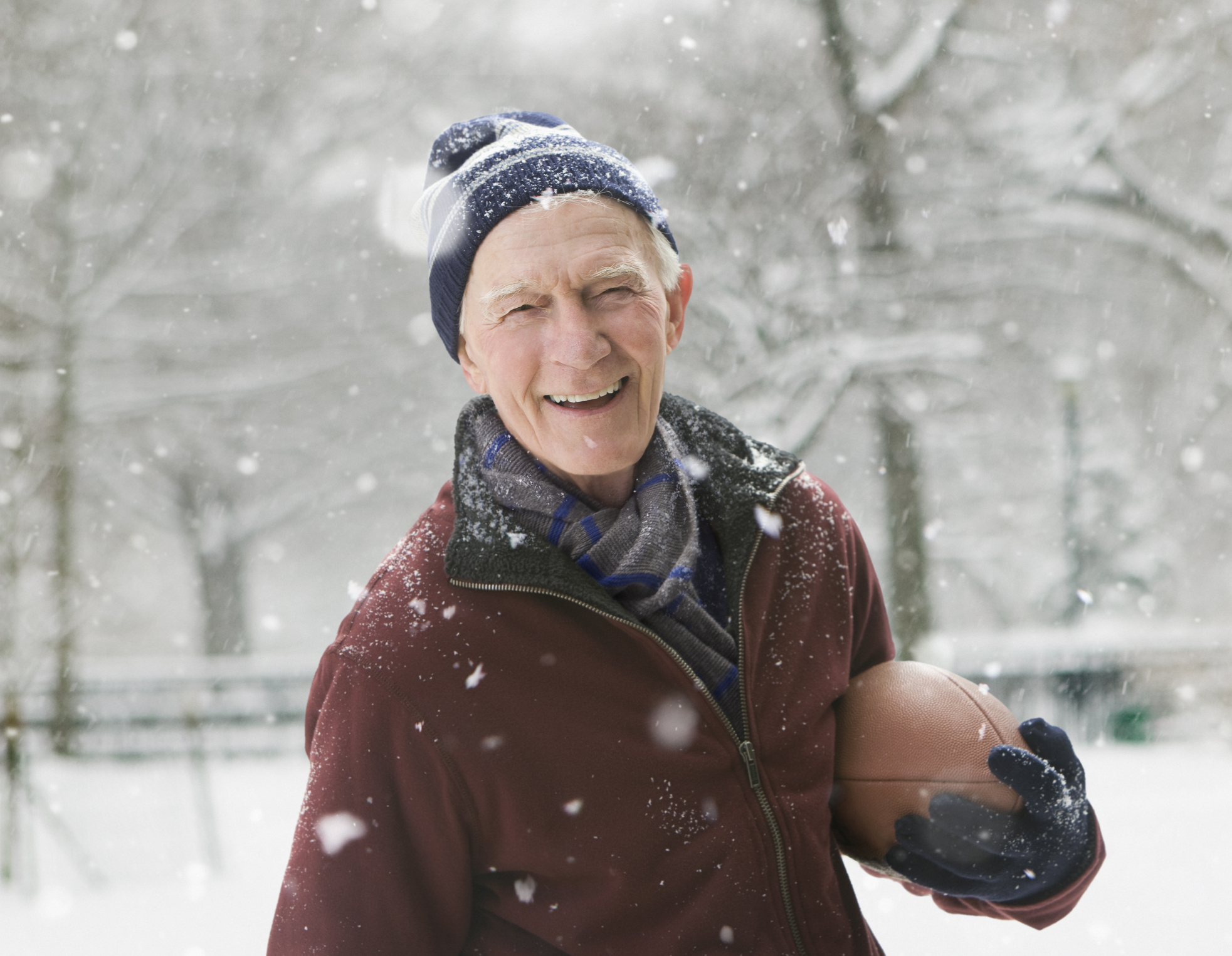 man holding a football in the snow