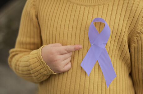 An epilepsy awareness ribbon pinned to child&#039;s sweater