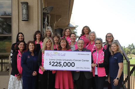 A group of people standing together on steps holding a check 