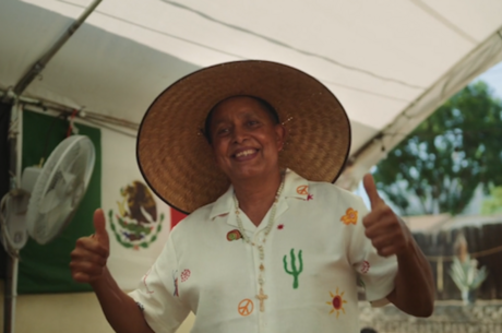 Patient jose Espinoza wearing a hat is facing the camera giving two thumbs up 