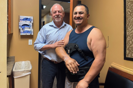 A doctor stands with a patient in recovery from an accident
