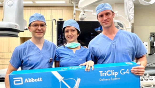 3 doctors holding large box of TriClips for new heart proceedure