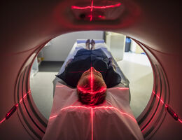 a man lays on a bed as he gets a medical scan