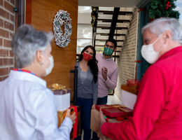 Parents visiting children for the holidays and everyone is wearing a mask