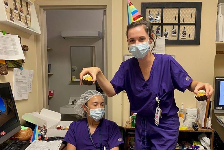 two residents celebrating a birthday with cupcakes