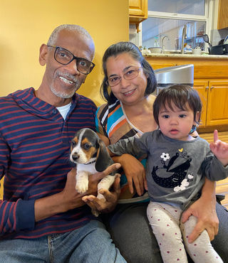 family smiling holding dog