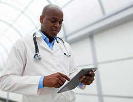 Doctor using tablet in medical walkway