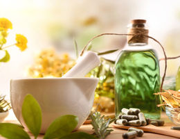 photo of oil bottles, herbs, and a white mixing bowl 