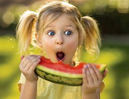 little girl eating watermelon looking surprised