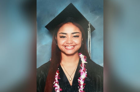 Abigail Aguilar smiling in a cap and gown in a formal graduation photo. 