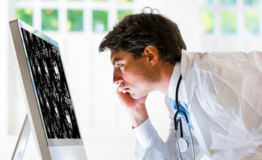 male doctor looking at cat scan