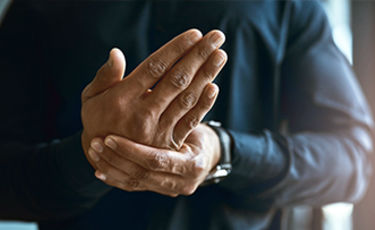 man holding hand in pain