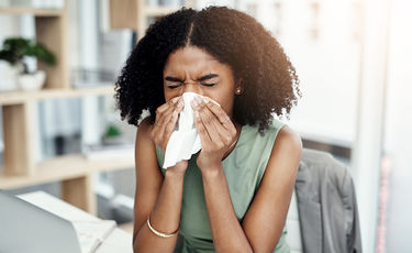 Women sneezing into a tissue