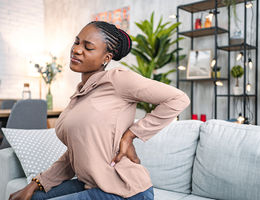 Woman holding her back in back paiin