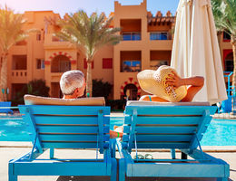older couple sitting by a resort pool