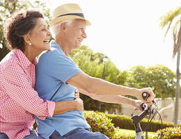 Older couple riding a bike to stay healthy