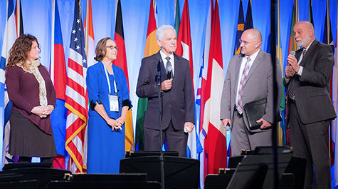 Dr. Hart on stage with a group of students