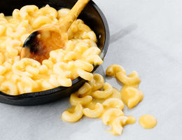 Mac and cheese in bowl with serving spoon