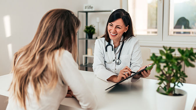 female doctor and patient happily talking in an office